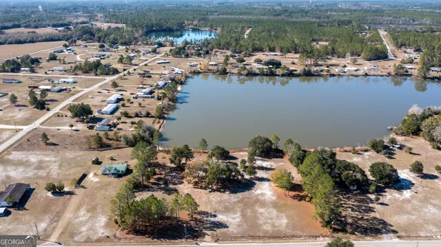 an aerial view of a house with a yard and lake view