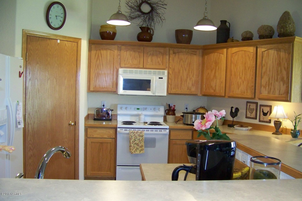 811 Red Tail Road Yakima, WA 98908 - Photo 13 of 35 a kitchen with stainless steel appliances granite countertop a sink dishwasher stove and cabinets