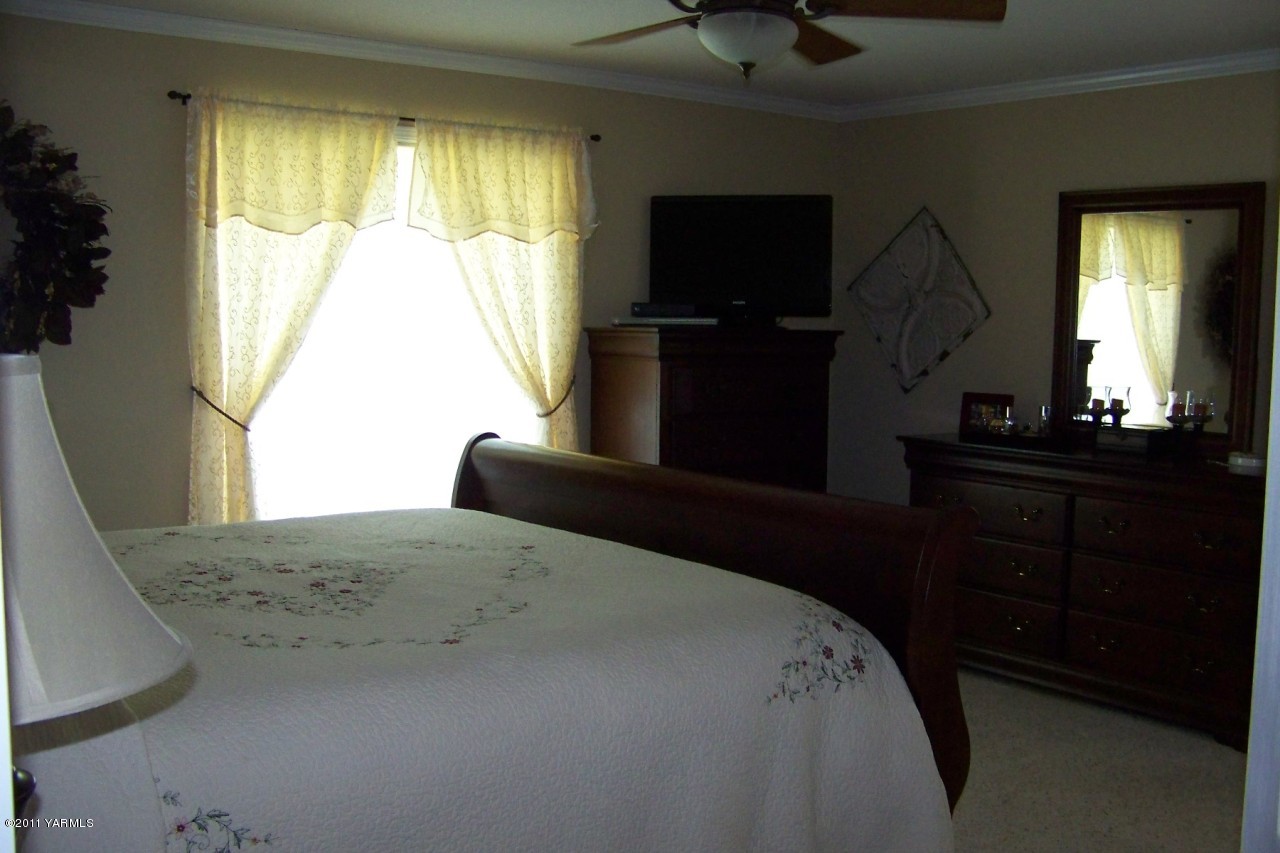 811 Red Tail Road Yakima, WA 98908 - Photo 19 of 35 a bedroom with a bed and a flat tv screen on dresser