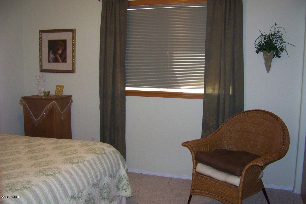 811 Red Tail Road Yakima, WA 98908 - Photo 27 of 35 a bedroom with a bed and a potted plant