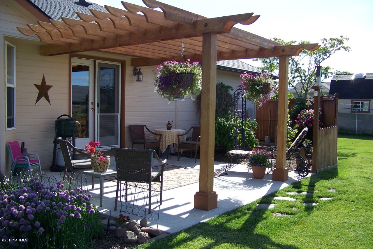 811 Red Tail Road Yakima, WA 98908 - Photo 31 of 35 a view of a patio with table and chairs potted plants and palm trees