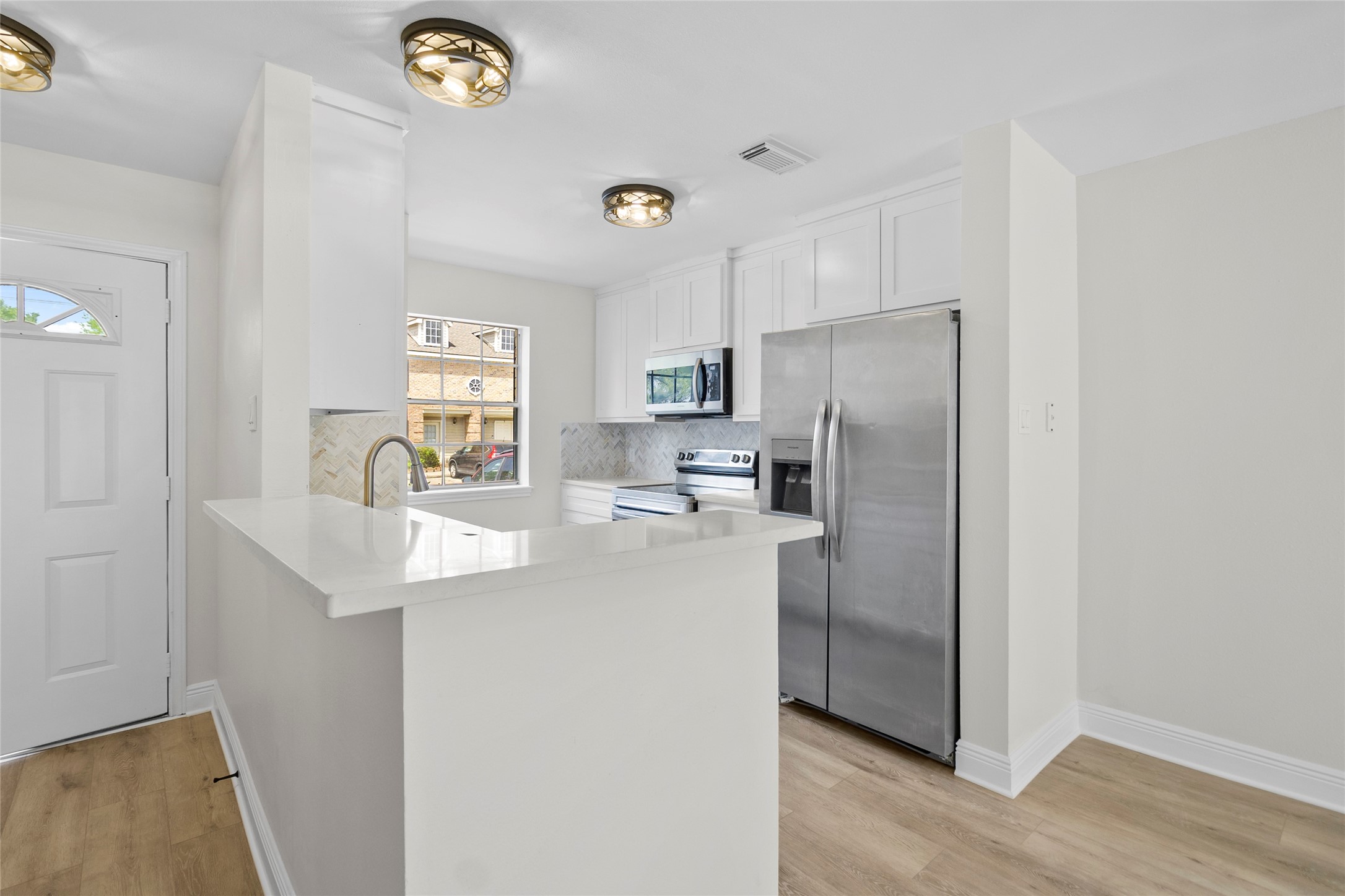 2030 Plantation Drive, Unit F3 Conroe, TX 77301 - Photo 5 of 22 a kitchen with stainless steel appliances granite countertop a refrigerator a sink a stove a dining table and chairs