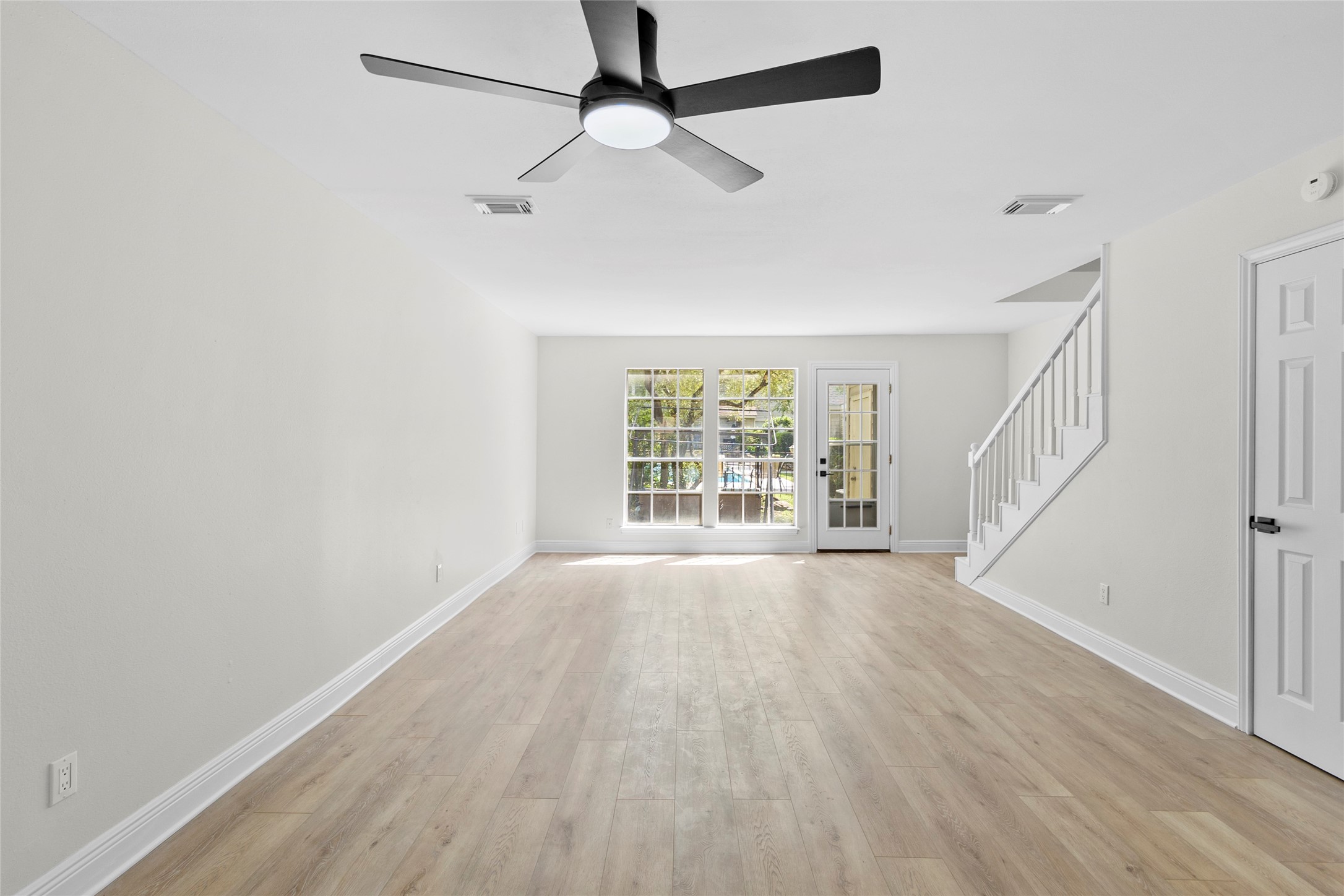 2030 Plantation Drive, Unit F3 Conroe, TX 77301 - Photo 7 of 22 a view of an empty room with wooden floor and a window