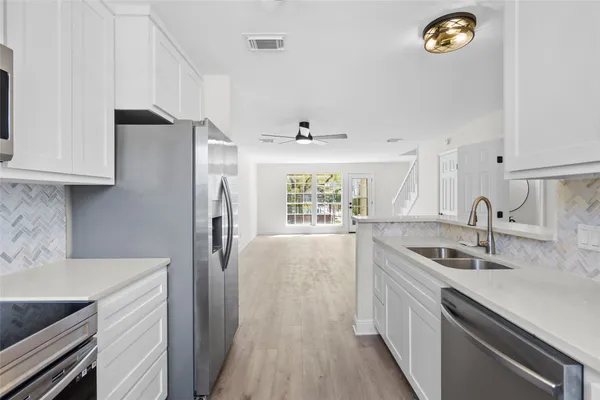 a kitchen with stainless steel appliances granite countertop a sink stove and refrigerator