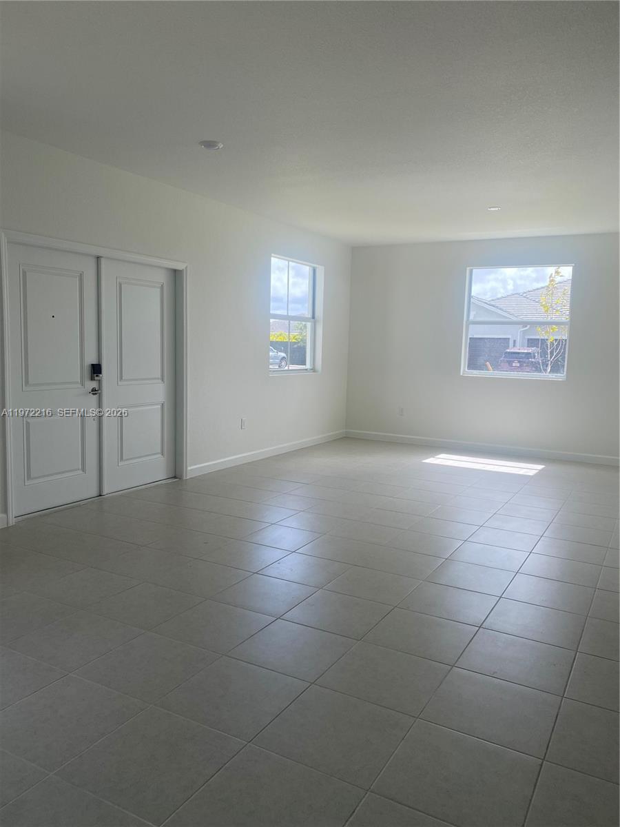 27441 Southwest 160th Avenue Homestead, FL 33031 - Photo 3 of 12 an empty room with a empty space and windows