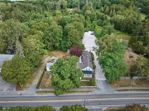 an aerial view of a house with a yard and large trees