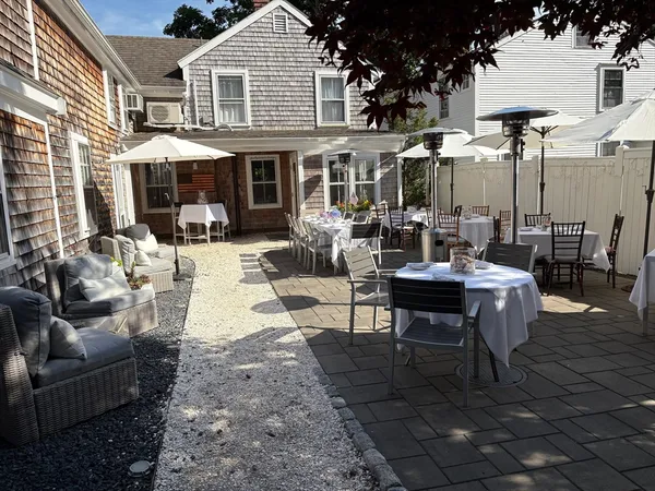 a view of a patio with couches table and chairs and potted plants