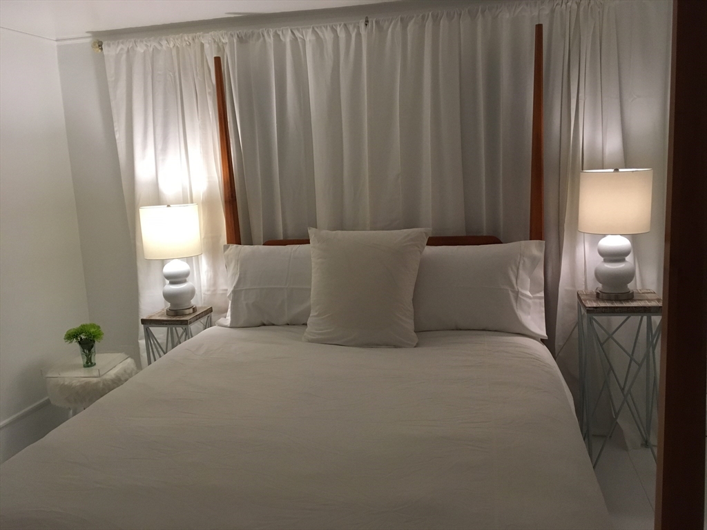 2019 Main Street Brewster, MA 02631 - Photo 9 of 17 a bed room with a bed and a lamp