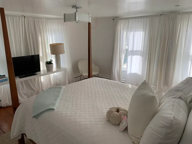 a bedroom with a bed and large window