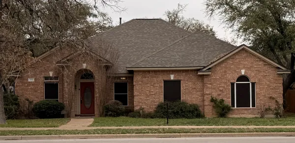 a front view of a house with a tree s