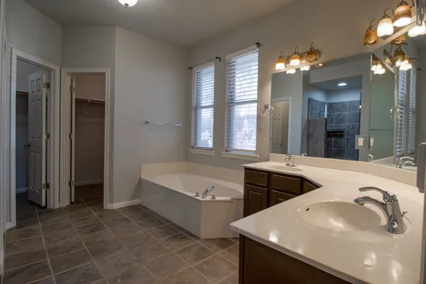 a bathroom with a tub sink and mirror