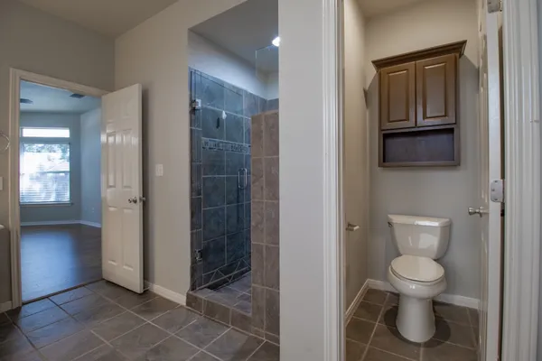 a bathroom with a toilet and a shower