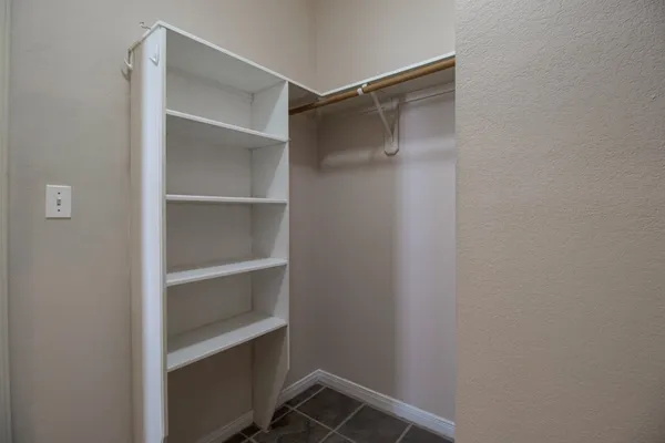a view of walk in closet with empty racks