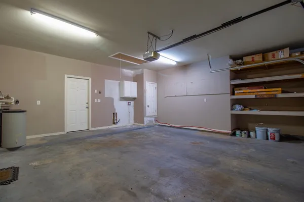 a view of an empty room with kitchen and a window