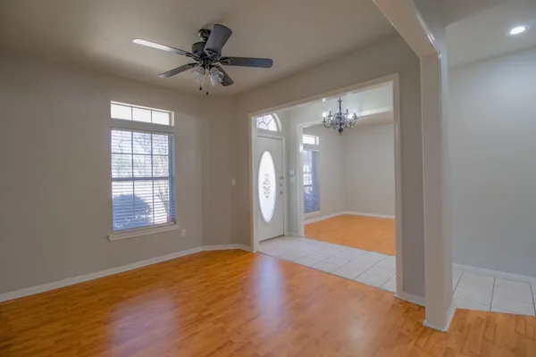 a view of an empty room with a window and wooden floor