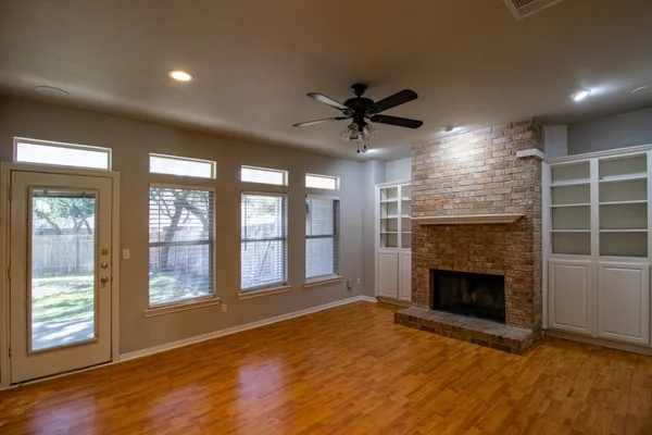a view of an empty room with a fireplace and a window