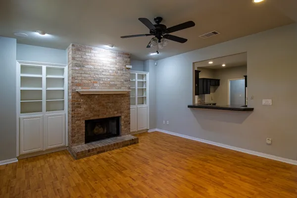 an empty room with windows and fireplace