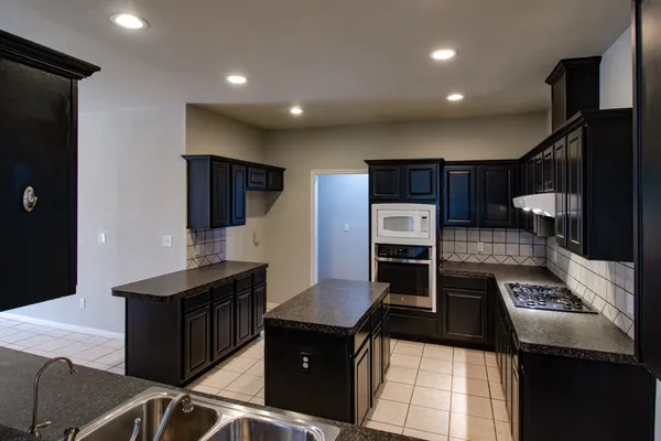 a kitchen with granite countertop a stove and a refrigerator