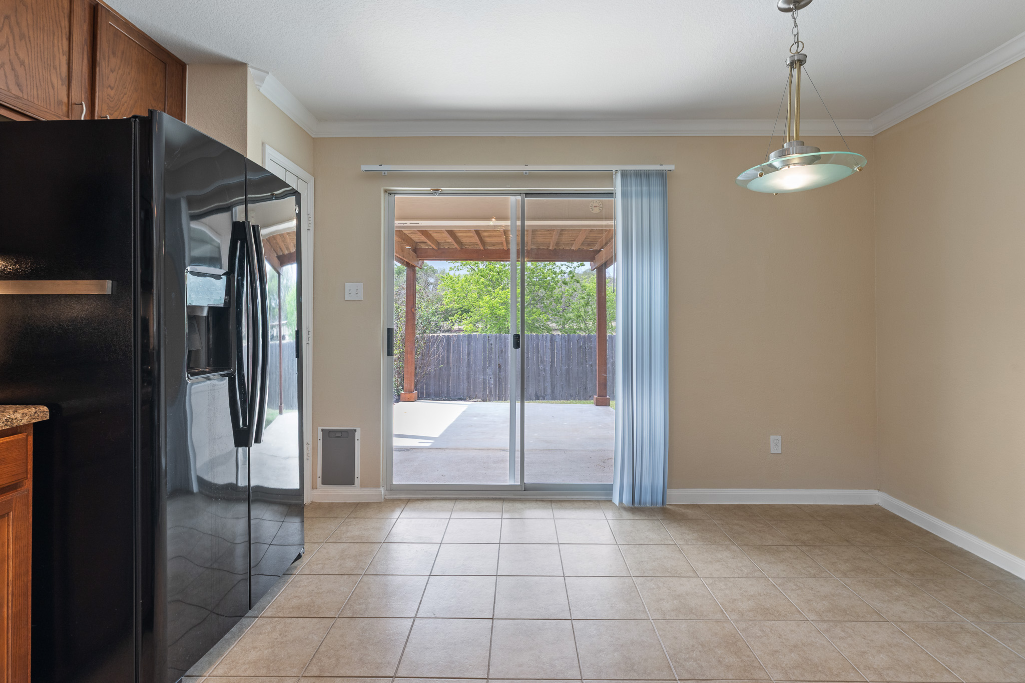 11400 Ashbrook Drive Manchaca, TX 78652 - Photo 12 of 32 a view of a kitchen with a refrigerator and an empty room