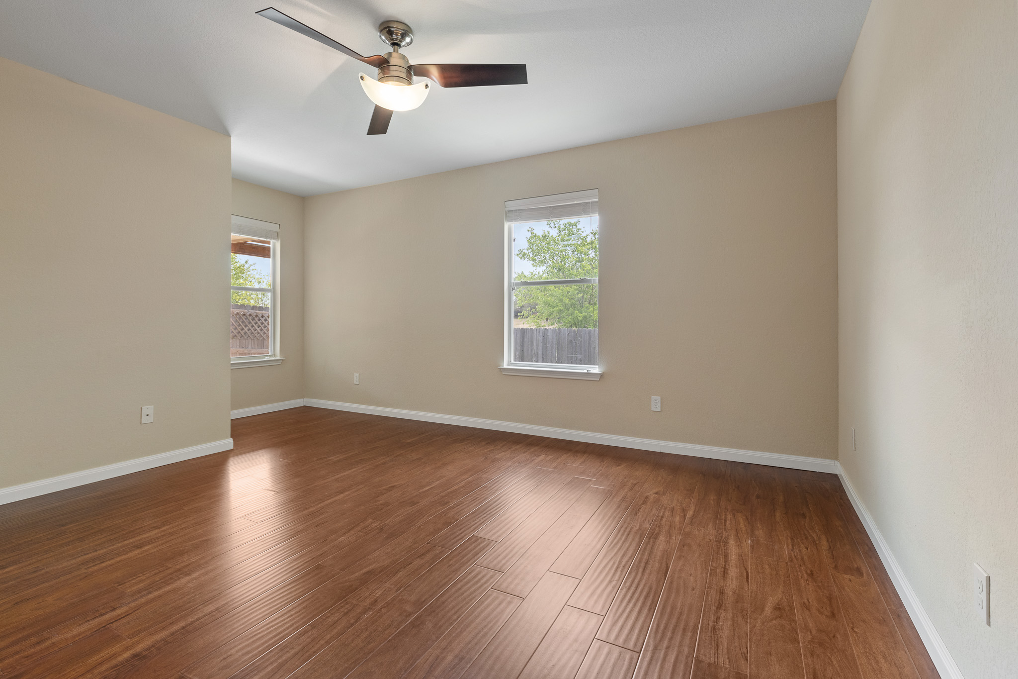 11400 Ashbrook Drive Manchaca, TX 78652 - Photo 15 of 32 an empty room with wooden floor ceiling fan and windows