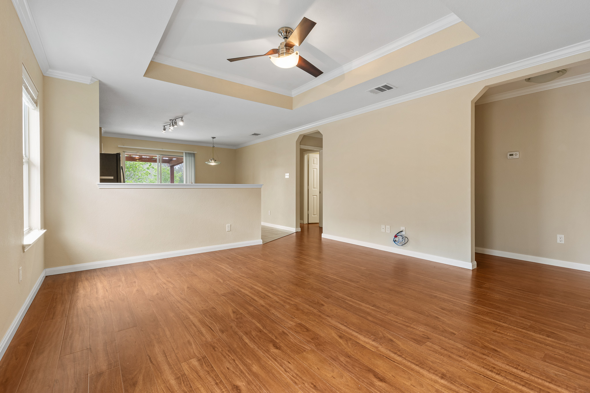 11400 Ashbrook Drive Manchaca, TX 78652 - Photo 3 of 32 a view of an empty room with wooden floor and a ceiling fan