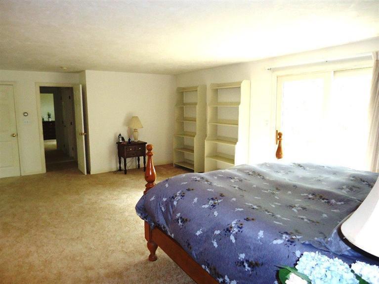 261 Simon Narrows Road Mashpee, MA 02649 - Photo 8 of 17 a bedroom with a bed and a chandelier