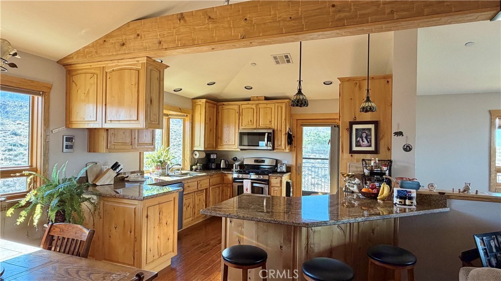 275 Canyon Road Pinon Hills, CA 92372 - Photo 24 of 68 a kitchen with stainless steel appliances granite countertop a stove refrigerator and cabinets