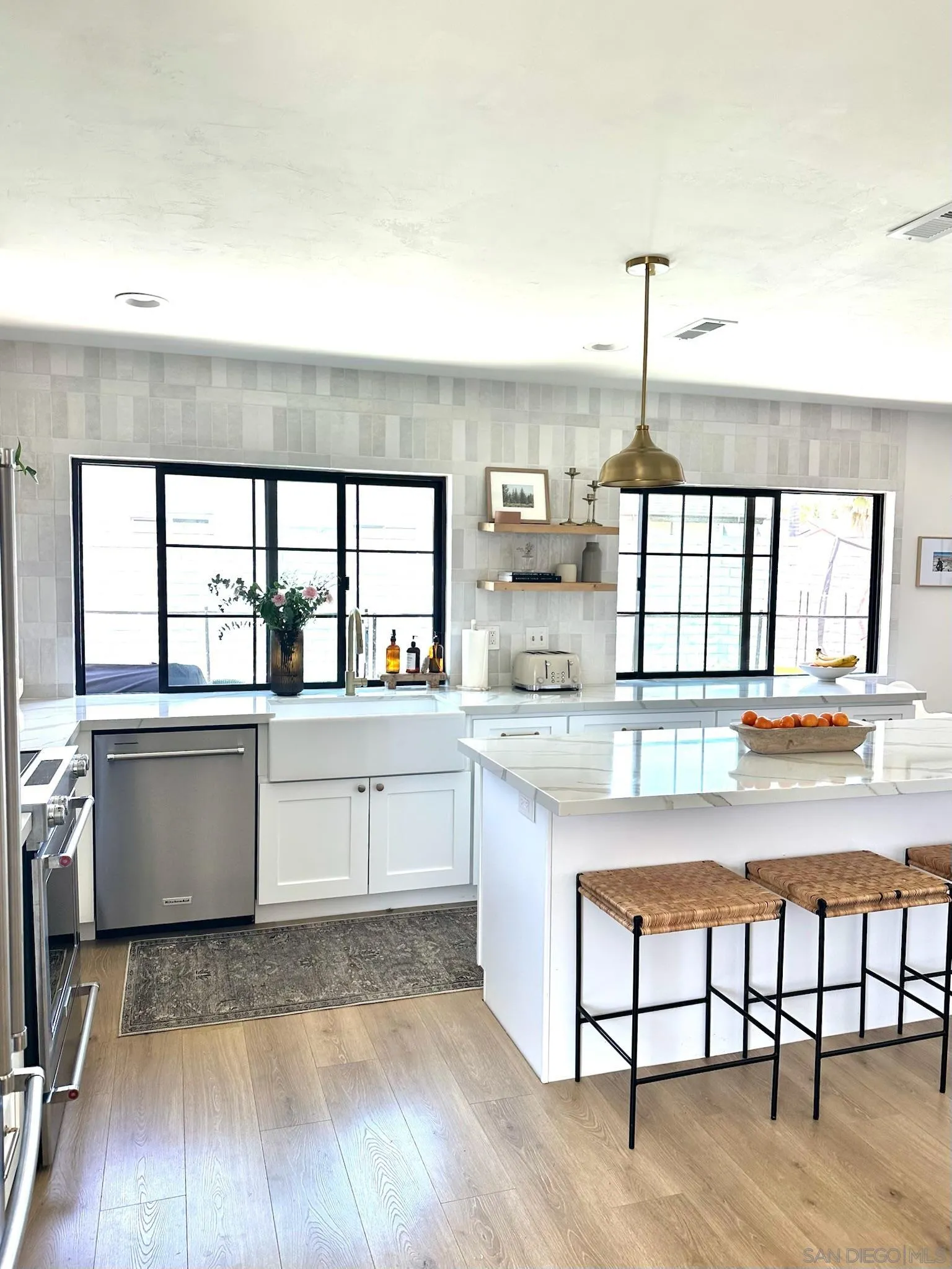 14240 Kendra Way Poway, CA 92064 - Photo 11 of 34 a kitchen with stainless steel appliances granite countertop a stove a sink and white cabinets with wooden floor