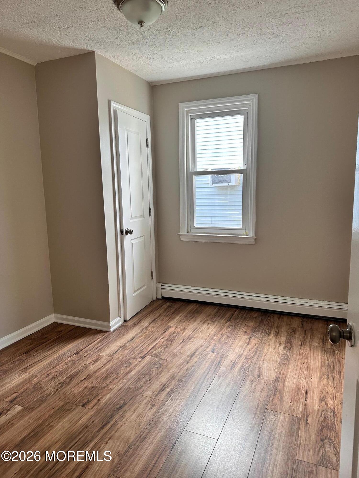 294 19th Avenue Brick, NJ 08724 - Photo 11 of 15 an empty room with wooden floor and windows