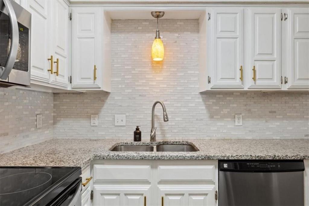 2306 Melissa Drive Waco, TX 76708 - Photo 10 of 22 a kitchen with granite countertop a sink stainless steel appliances and white cabinets
