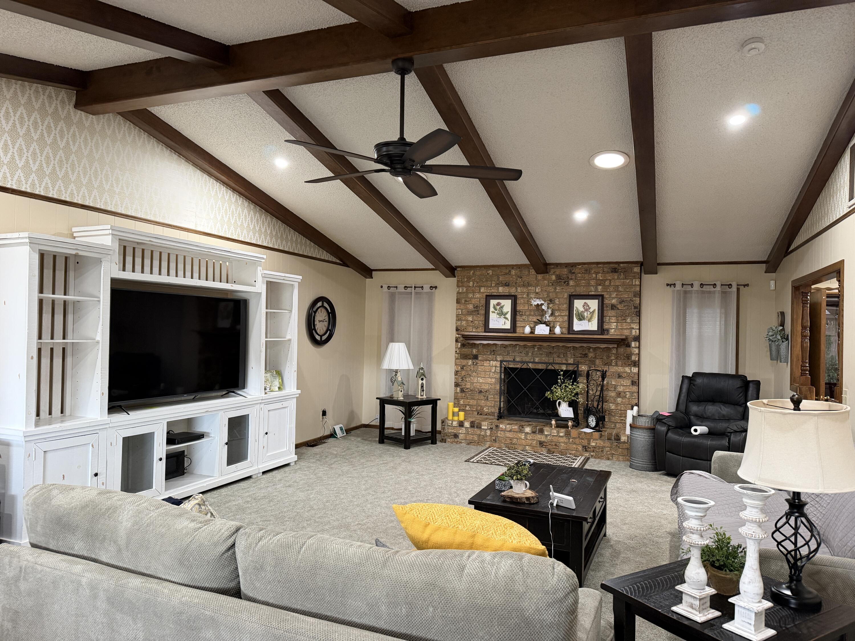 1603 South 8th Street Lamesa, TX 79331 - Photo 3 of 39 a living room with furniture a flat screen tv and a fireplace