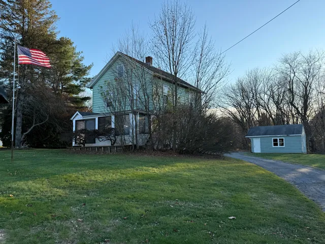 a backyard of a house with table and chairs