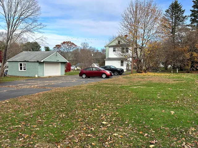 a yellow and red house sitting in the middle of a yard
