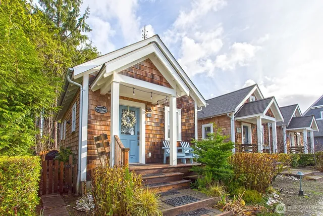 a view of a white house next to a yard