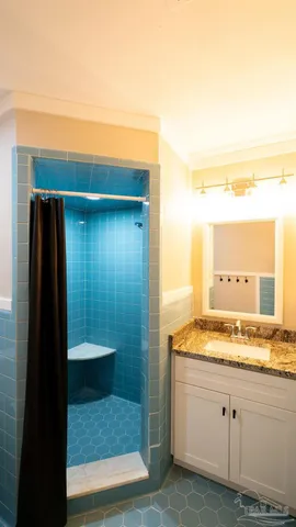 a bathroom with a granite countertop shower and a sink