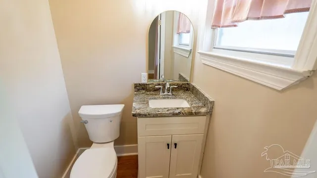 a bathroom with a granite countertop toilet and a sink