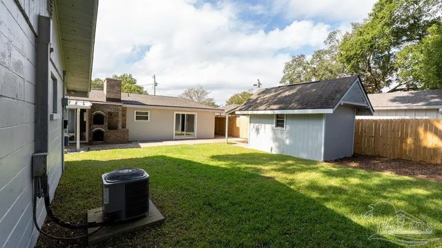 a front view of house with yard and trees in the background