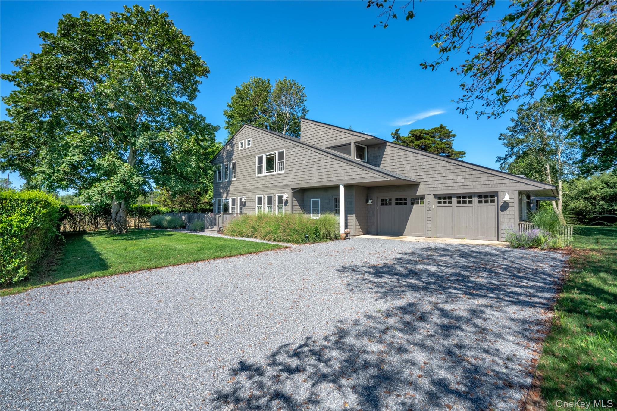 a view of a house with a yard and large trees