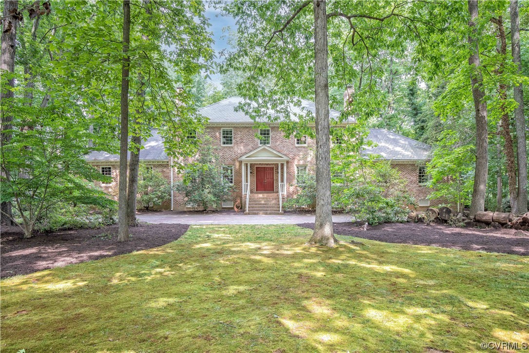 a view of a house with a yard and sitting area