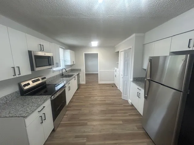 a kitchen with refrigerator and microwave