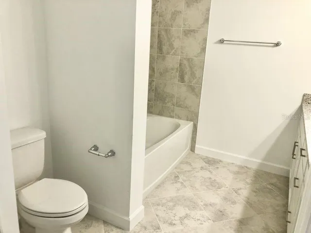 a white toilet sitting next to a bath tub and shower