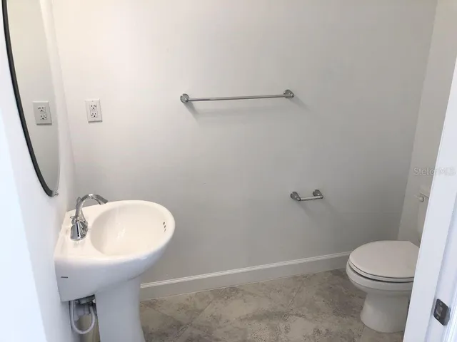 a bathroom with a sink toilet and a mirror