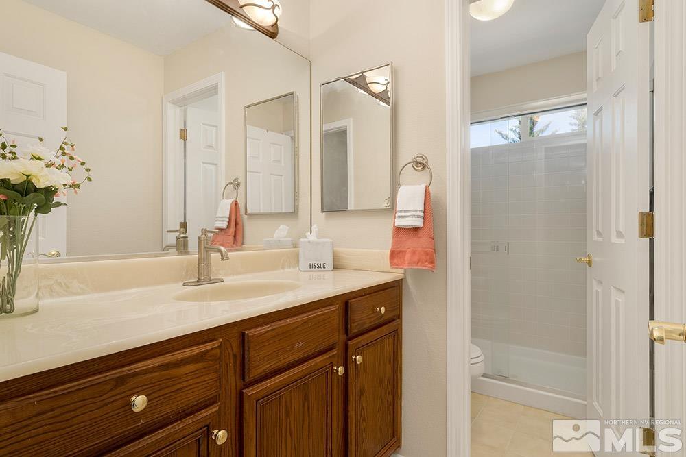 14320 Ghost Rider Drive Reno, NV 89511 - Photo 22 of 40 a bathroom with a sink vanity granite and a mirror