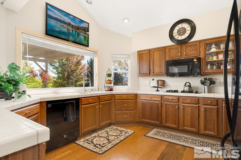 14320 Ghost Rider Drive Reno, NV 89511 - Photo 10 of 40 a kitchen with stainless steel appliances granite countertop a stove a sink and a microwave