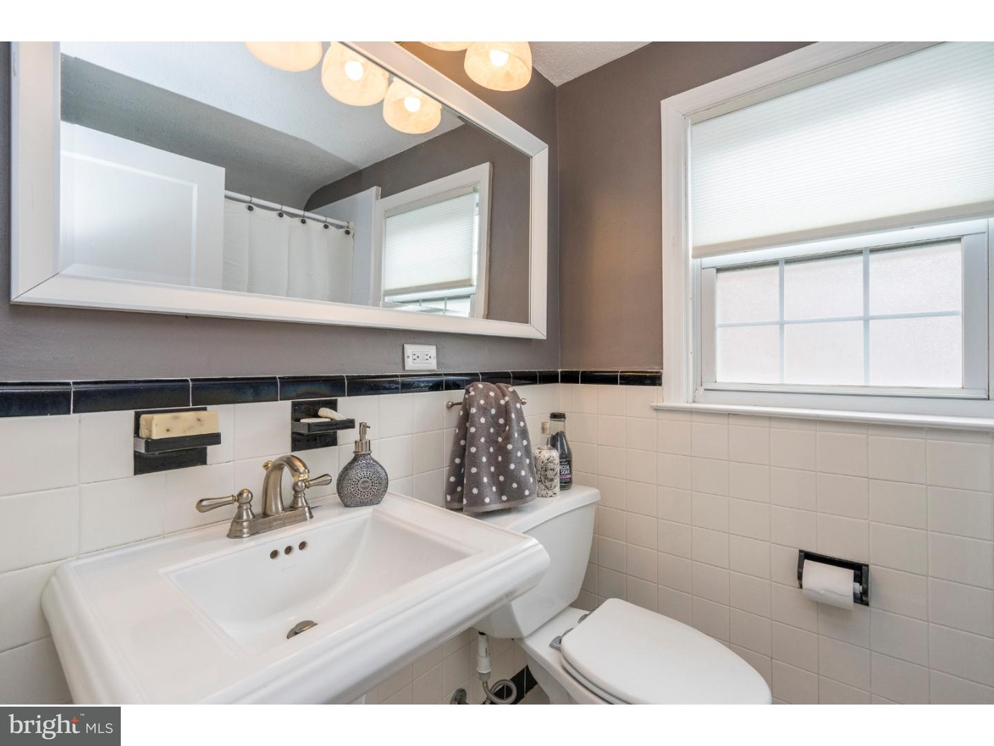 100 Kent Road Springfield, PA 19064 - Photo 18 of 22 a bathroom with a sink a mirror and a toilet