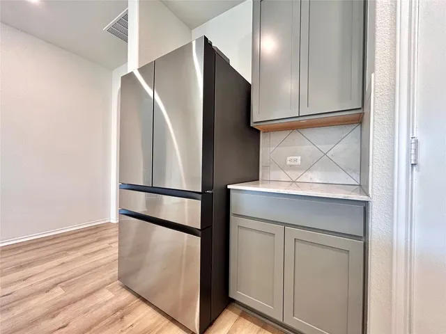 a metallic refrigerator freezer sitting in a kitchen