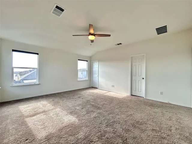 an empty room with windows and fan