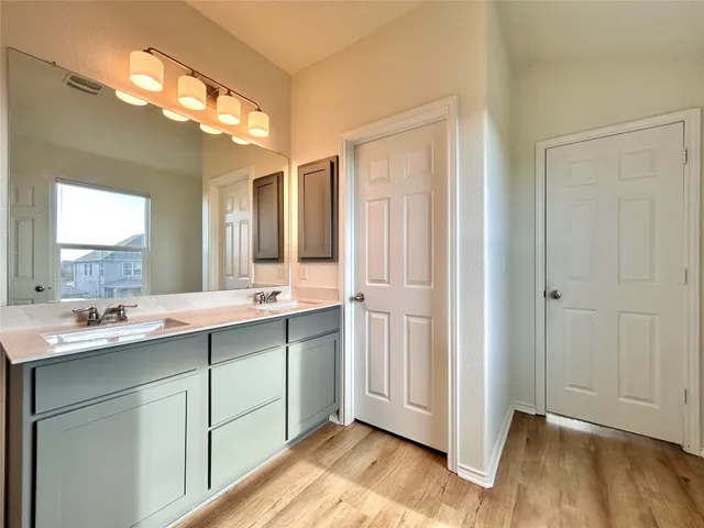 a bathroom with a double vanity sink and mirror with shower