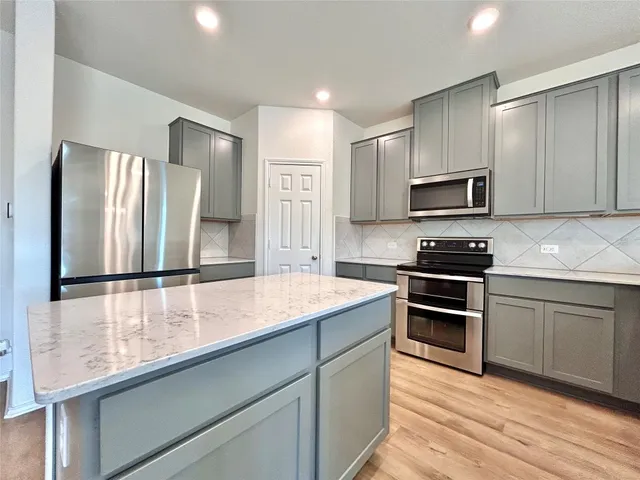 a kitchen with stainless steel appliances a refrigerator sink and stove