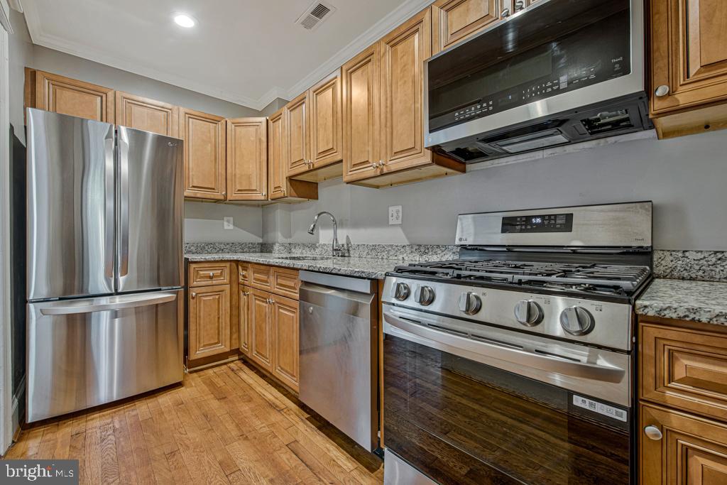 2406 37th Street Northwest Washington, DC 20007 - Photo 11 of 44 a kitchen with stainless steel appliances granite countertop a refrigerator stove and microwave